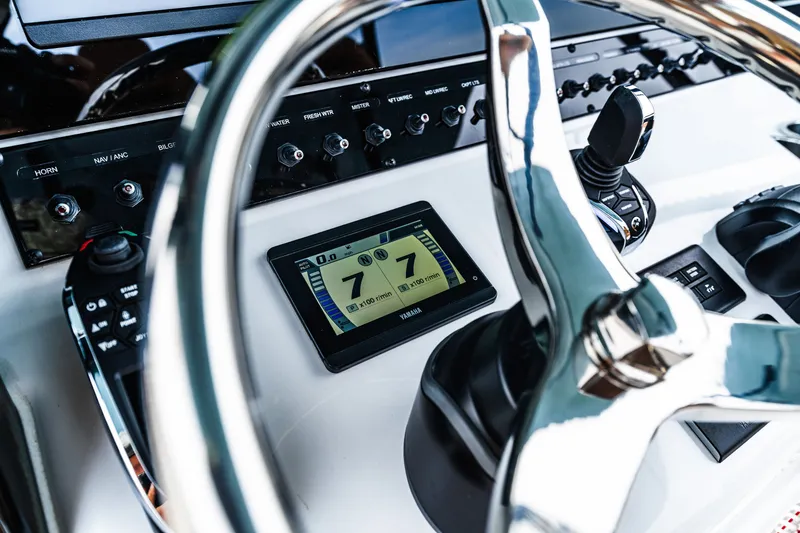 Slide: The Image of Control panel of 2026 Sea Hunt Ultra 305SE boat with steering wheel and digital display. - 18
