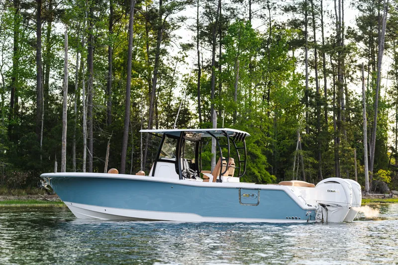 Slide: The Image of 2026 Sea Hunt Ultra 305SE boat cruising on a serene lake, surrounded by lush trees. - 5