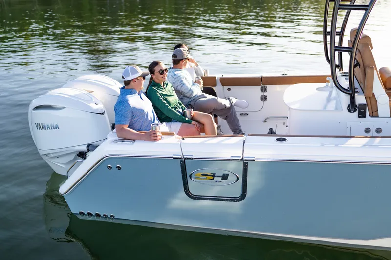Slide: The Image of People relaxing on a 2026 Sea Hunt Ultra 305SE boat on calm water. - 41