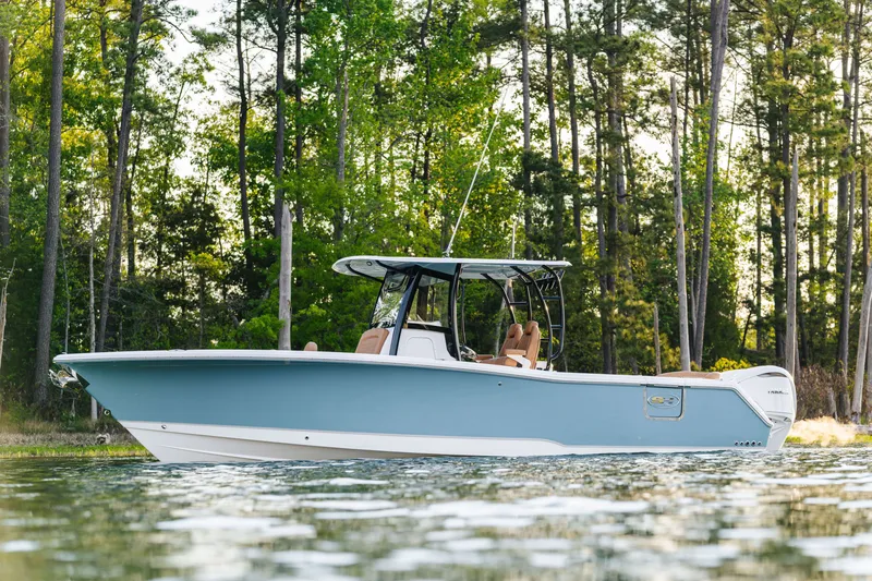 Slide: The Image of 2026 Sea Hunt Ultra 305SE boat on calm water, surrounded by lush trees. - 29