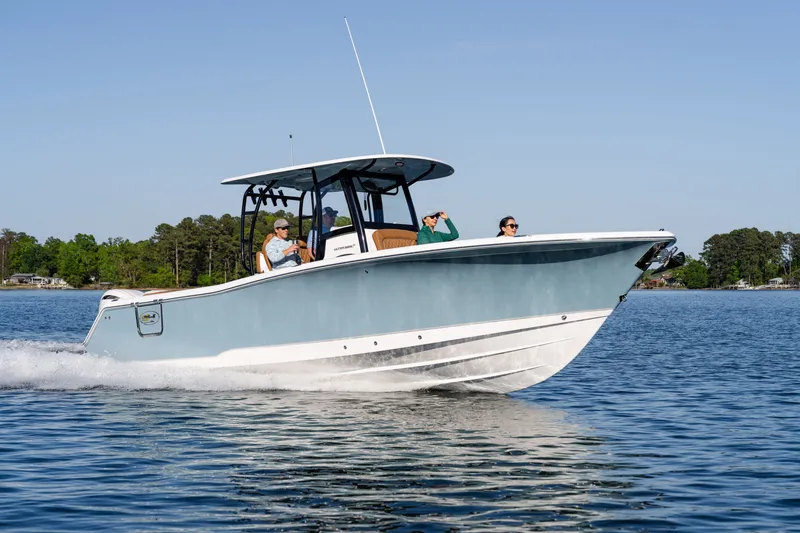 Slide: The Image of 2026 Sea Hunt Ultra 305SE boat cruising on a serene lake with passengers onboard. - 38