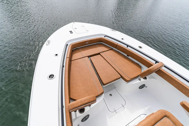 Slide: The Image of 2026 Sea Hunt Ultra 305SE boat with tan seating, docked on calm water. - 6