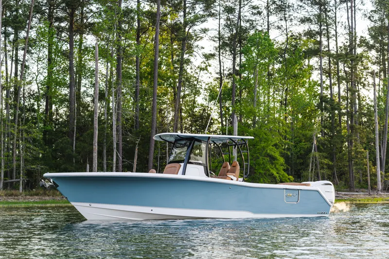 Slide: The Image of 2026 Sea Hunt Ultra 305SE boat cruising on a serene lake with forest backdrop. - 3