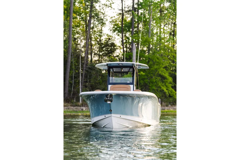 Slide: The Image of 2026 Sea Hunt Ultra 305SE boat on calm water, surrounded by lush greenery. - 2