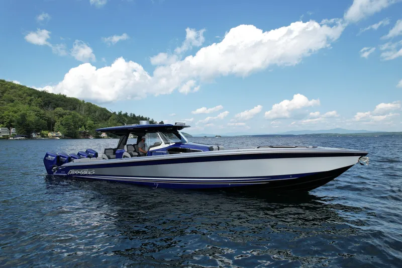 Slide: The Image of 2027 Nor-Tech 450 Sport boat cruising on a scenic lake under a clear blue sky. - 16