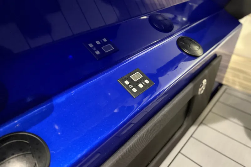Slide: The Image of Control panel on a blue 2027 Nor-Tech 450 Sport boat dashboard. - 37