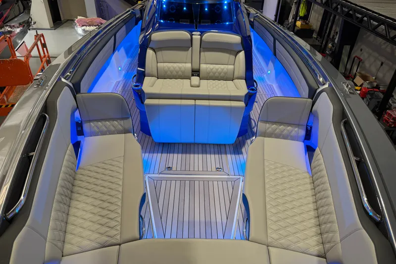 Slide: The Image of 2027 Nor-Tech 450 Sport boat interior with luxurious seating and ambient blue lighting. - 21