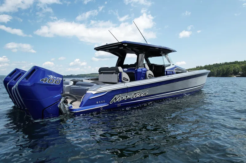 Slide: The Image of 2027 Nor-Tech 450 Sport boat with triple Racing 400 engines on a sunny lake. - 14