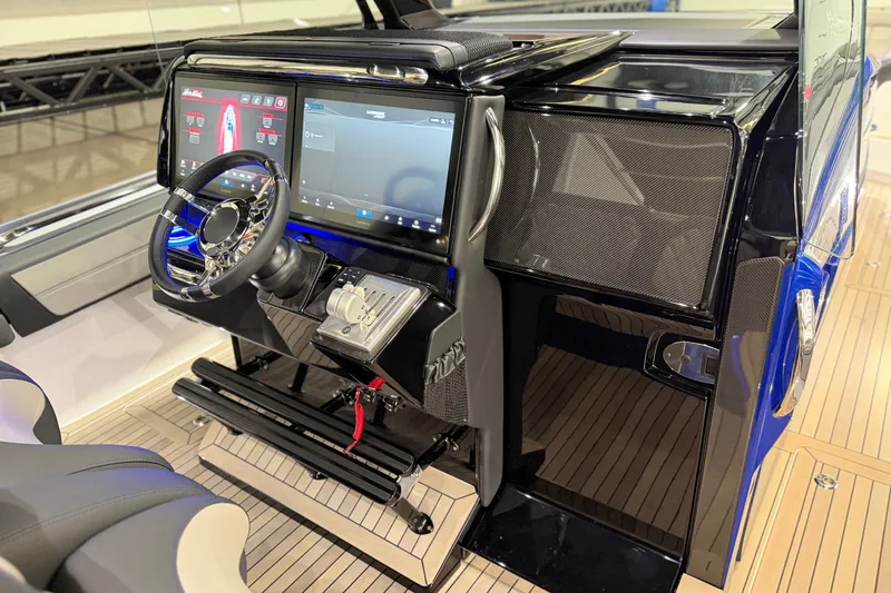 Slide: The Image of 2027 Nor-Tech 450 Sport boat cockpit with advanced digital controls and sleek steering wheel. - 31