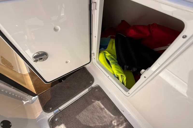 Slide: The Image of Open storage compartment on 2011 Regal 2700 ES Bowrider with life jackets inside. - 25