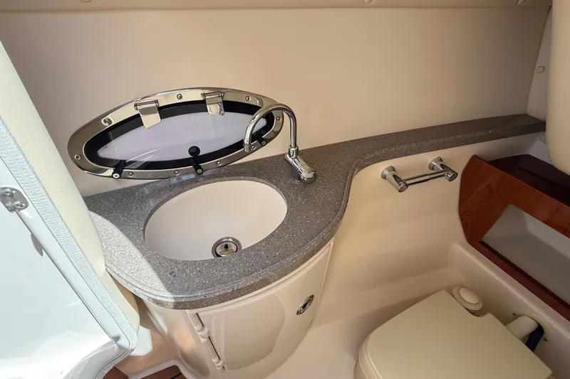 Slide: The Image of Interior of 2011 Regal 2700 ES Bowrider boat bathroom with sink and porthole window. - 21