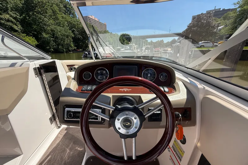 Slide: The Image of Cockpit view of 2011 Regal 2700 ES Bowrider with steering wheel and dashboard controls. - 16