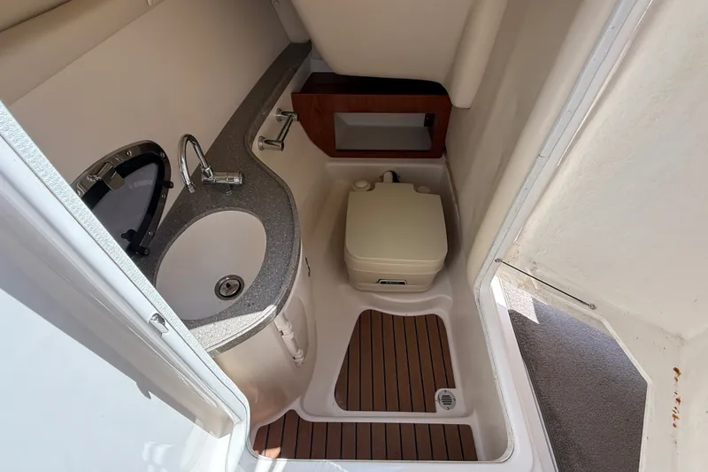 Slide: The Image of 2011 Regal 2700 ES Bowrider boat bathroom with sink and portable toilet. - 22