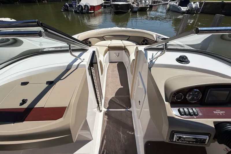 Slide: The Image of 2011 Regal 2700 ES Bowrider interior with dashboard and seating, docked at marina. - 23