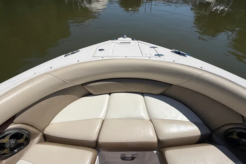 Slide: The Image of 2011 Regal 2700 ES Bowrider boat interior with beige seating on calm water. - 29