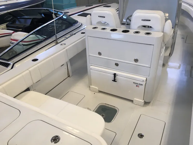 Slide: The Image of The image shows the cockpit of a 2017 Contender 32 ST boat with white seating and storage. - 23