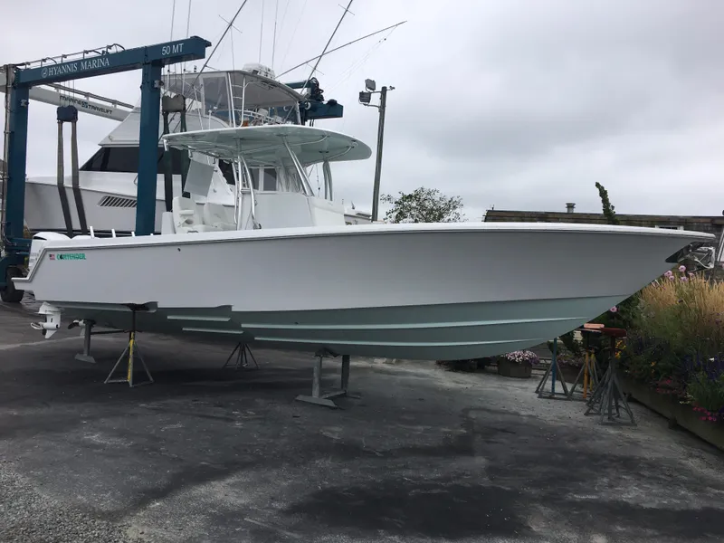 Slide: The Image of A 2017 Contender 32 ST boat is on a dry dock. It features a sleek, white design. - 19