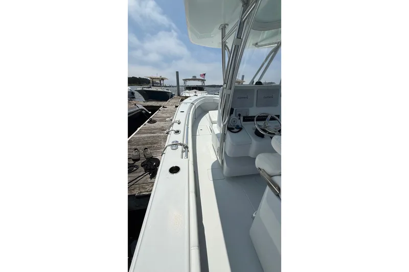 Slide: The Image of 2017 Contender 32 ST boat docked, showcasing sleek design and spacious deck. - 14