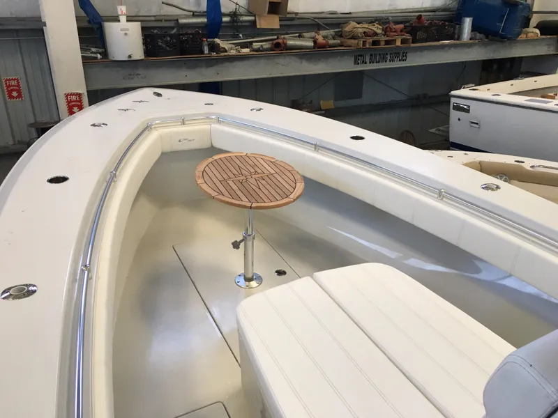 Slide: The Image of The image shows the bow of a 2017 Contender 32 ST boat with a round wooden table. - 28