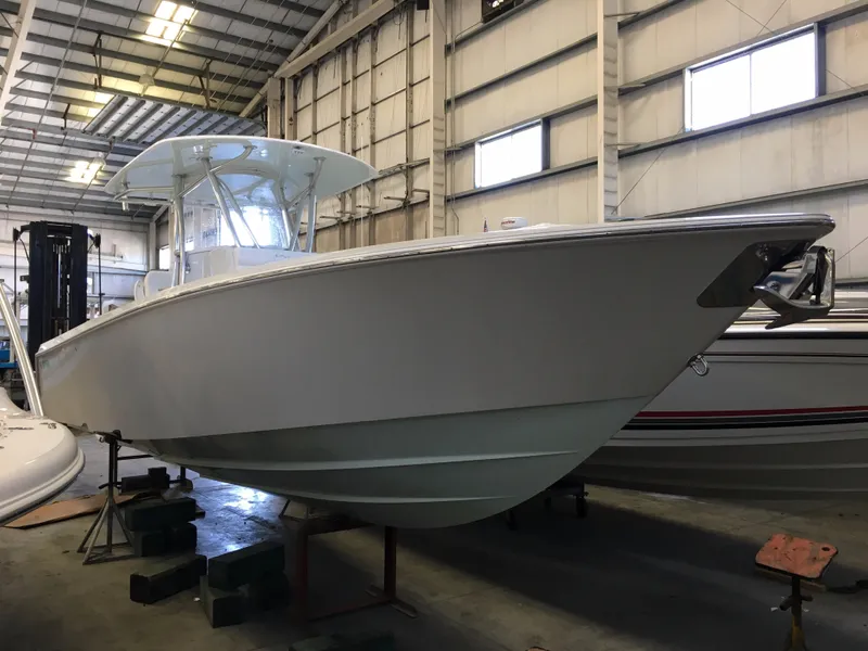 Slide: The Image of A 2017 Contender 32 ST boat is in a warehouse. It features a white deck and hardtop. - 21