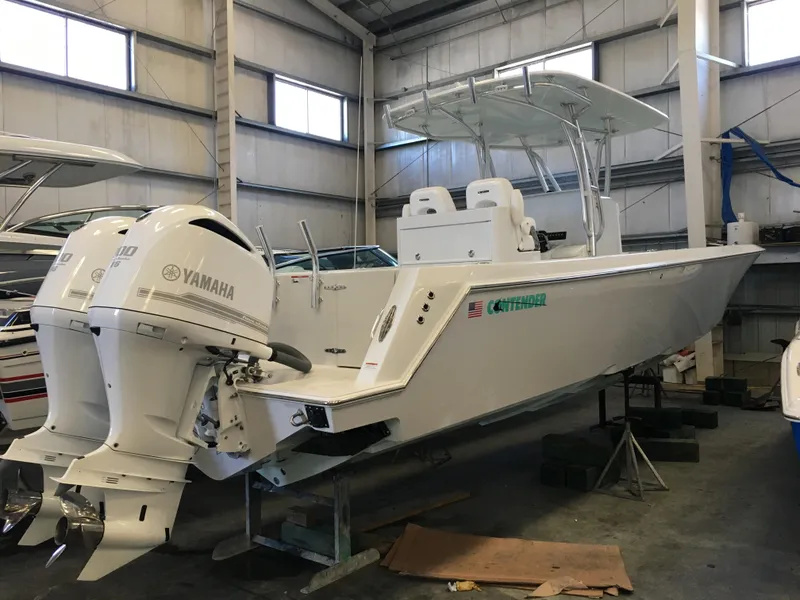 Slide: The Image of A 2017 Contender 32 ST boat in a warehouse, featuring twin Yamaha outboard engines. - 22