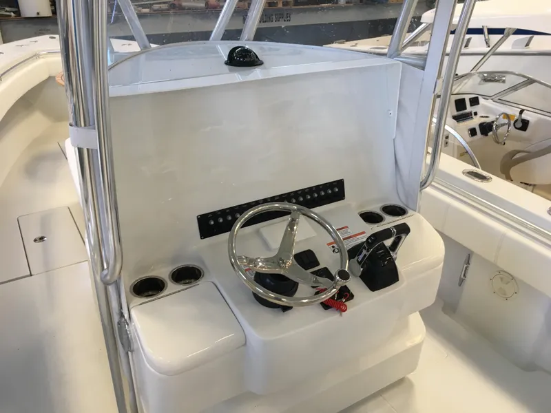 Slide: The Image of The image shows the helm of a 2017 Contender 32 ST boat with a stainless steel steering wheel. - 24