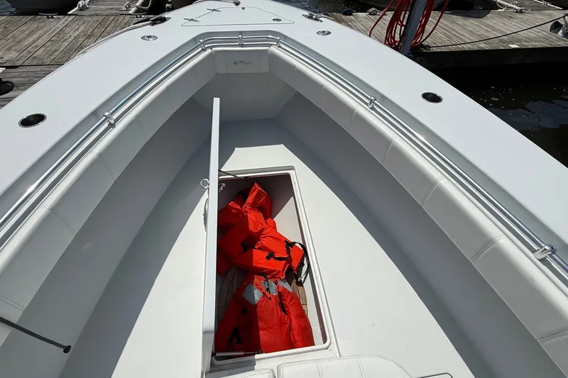 Slide: The Image of 2017 Contender 32 ST boat with open storage compartment containing red life jackets. - 13