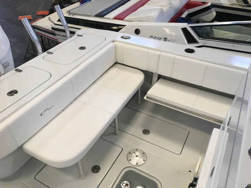 Slide: The Image of The image shows the cockpit of a 2017 Contender 32 ST boat with white cushioned seating. - 26