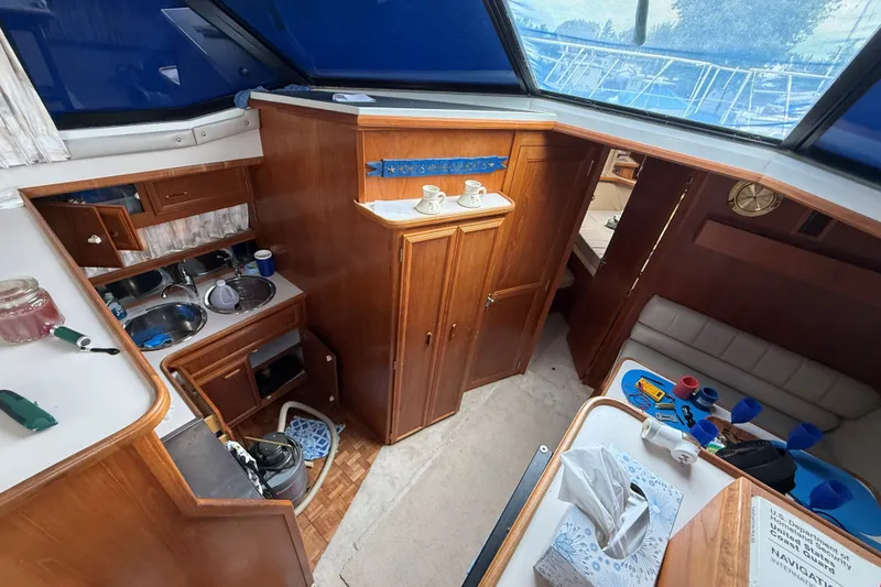 Slide: The Image of Interior of 1988 Carver 38 Aft Cabin Motor Yacht, featuring kitchen and seating area. - 35
