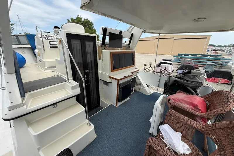 Slide: The Image of 1988 Carver 38 Aft Cabin Motor Yacht interior with wicker chairs and entertainment setup. - 23