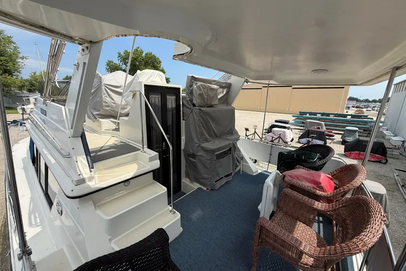 Slide: The Image of 1988 Carver 38 Aft Cabin Motor Yacht deck with wicker chairs and covered equipment. - 7