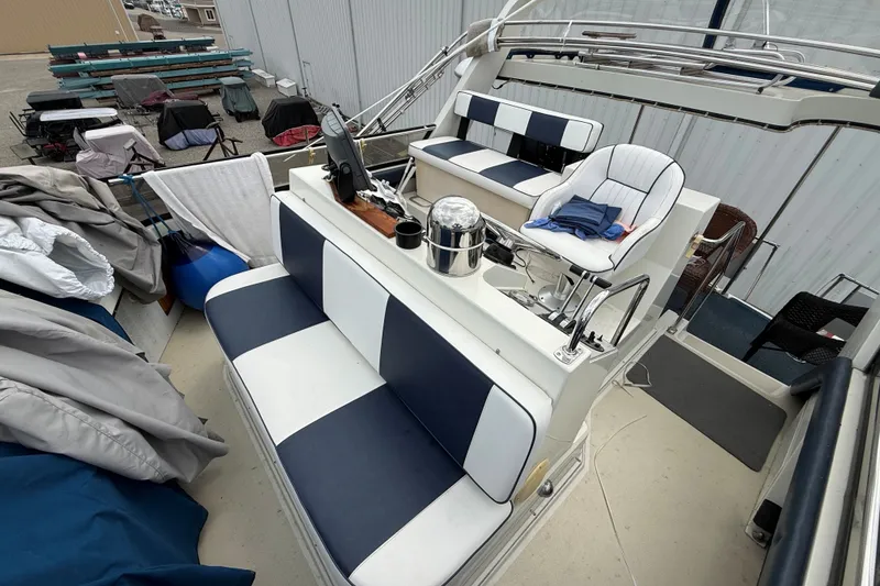 Slide: The Image of 1988 Carver 38 Aft Cabin Motor Yacht interior with striped seating and helm station. - 22