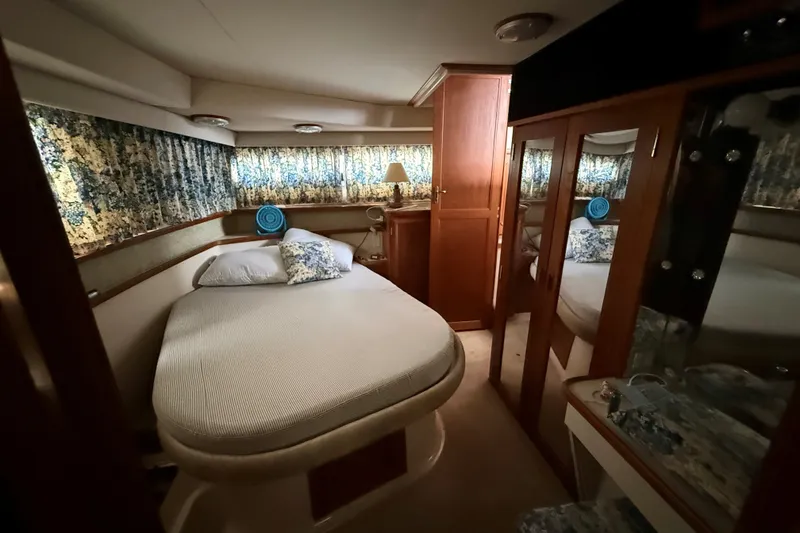 Slide: The Image of 1988 Carver 38 Aft Cabin Motor Yacht bedroom with cozy bed and floral curtains. - 33