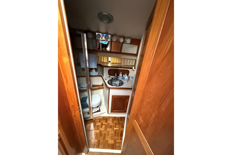 Slide: The Image of 1988 Carver 38 Aft Cabin Motor Yacht bathroom with wood accents and compact design. - 39