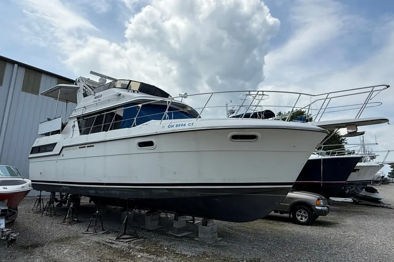 The Image of 1988 Carver 38 Aft Cabin Motor Yacht on stands, under a cloudy sky. - 0