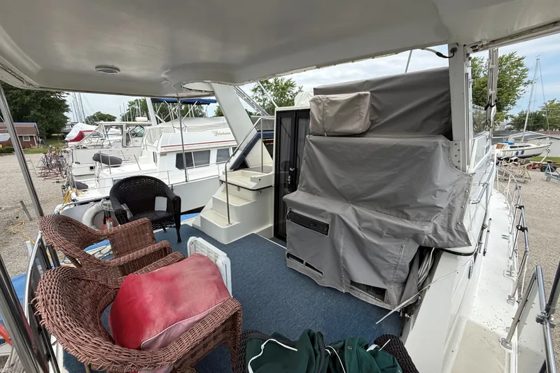 Slide: The Image of 1988 Carver 38 Aft Cabin Motor Yacht deck with wicker chairs and covered equipment. - 12