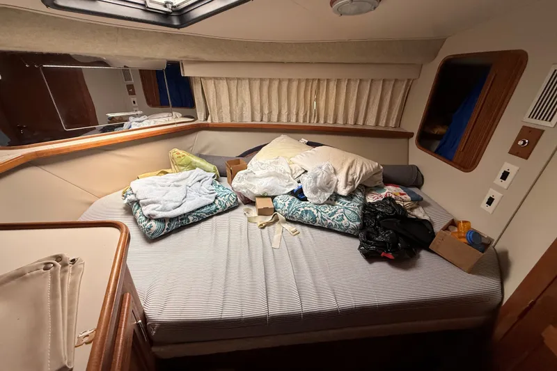 Slide: The Image of Interior of 1988 Carver 38 Aft Cabin Motor Yacht bedroom with cluttered bed. - 41