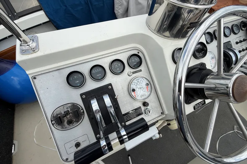 Slide: The Image of Helm controls of a 1988 Carver 38 Aft Cabin Motor Yacht, featuring gauges and steering wheel. - 19