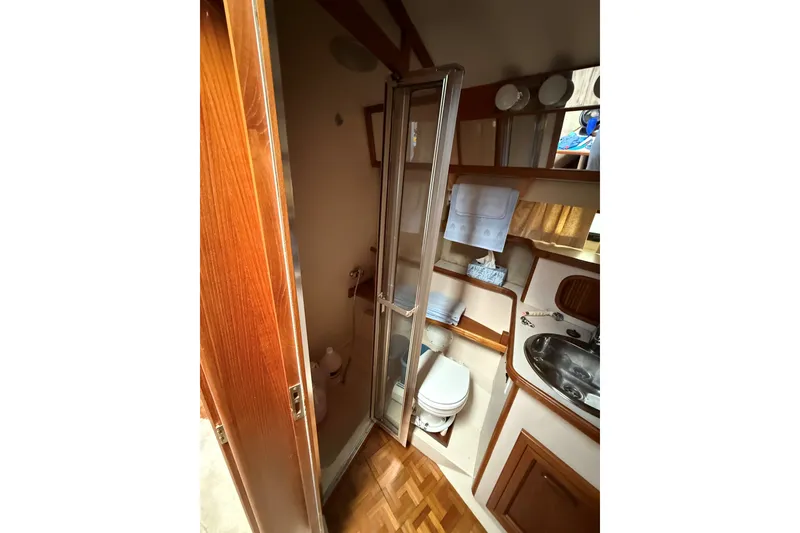 Slide: The Image of 1988 Carver 38 Aft Cabin Motor Yacht bathroom with shower, sink, and wooden accents. - 40