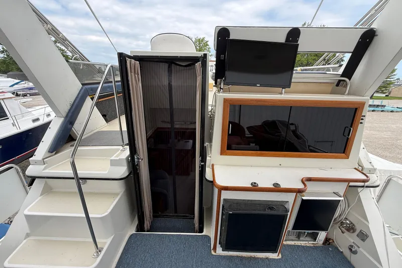 Slide: The Image of 1988 Carver 38 Aft Cabin Motor Yacht interior with stairs, TV, and kitchenette. - 24