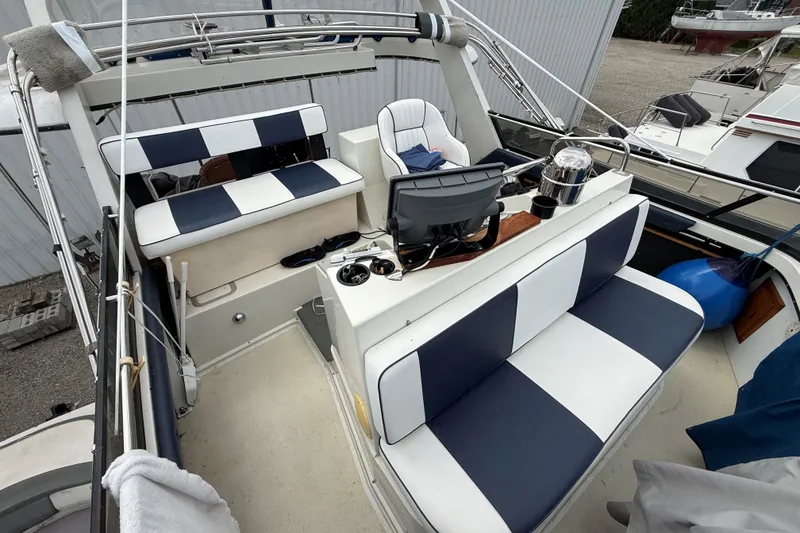 Slide: The Image of 1988 Carver 38 Aft Cabin Motor Yacht interior with striped seating and helm station. - 21