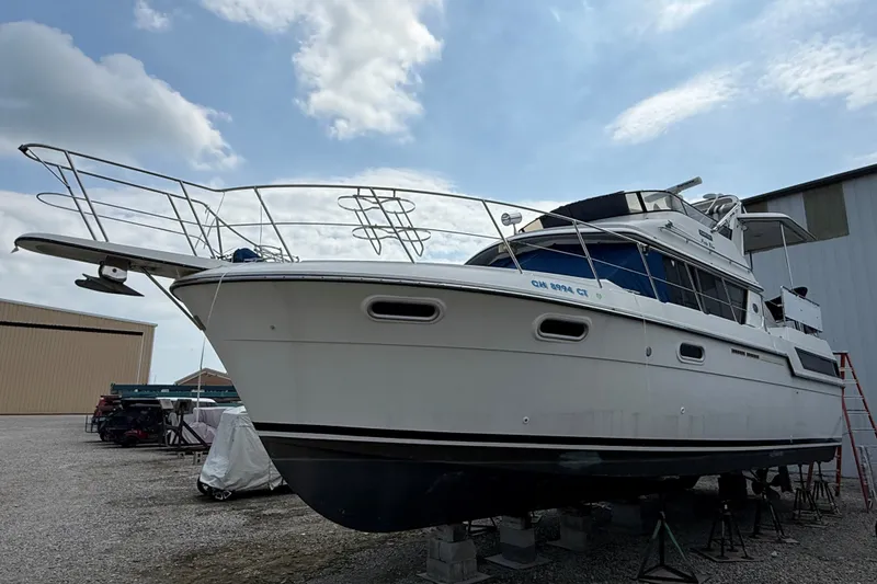 Slide: The Image of 1988 Carver 38 Aft Cabin Motor Yacht on dry dock under a partly cloudy sky. - 1