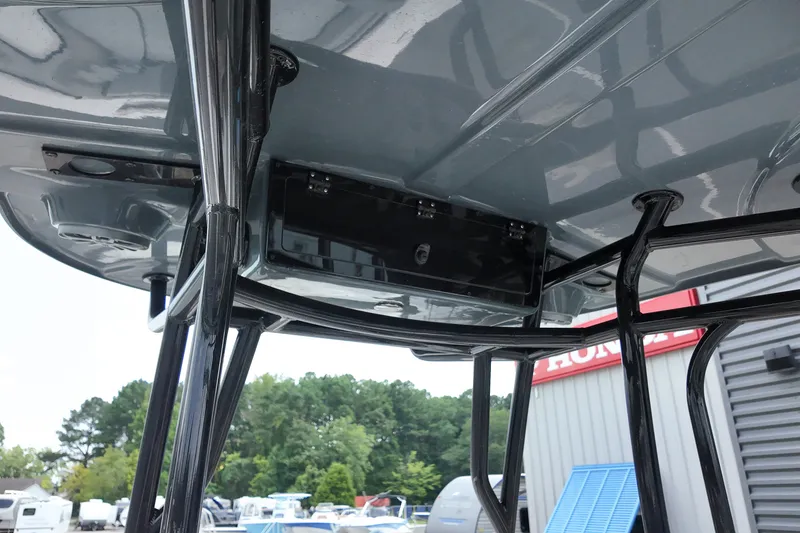 Slide: The Image of 2027 Carolina Skiff 22 Ultra Elite T-top structure with storage compartment, outdoor setting. - 14