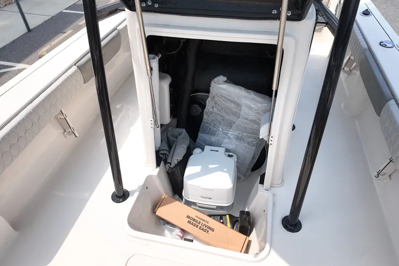 Slide: The Image of Storage compartment of 2027 Carolina Skiff 22 Ultra Elite boat with various items inside. - 11