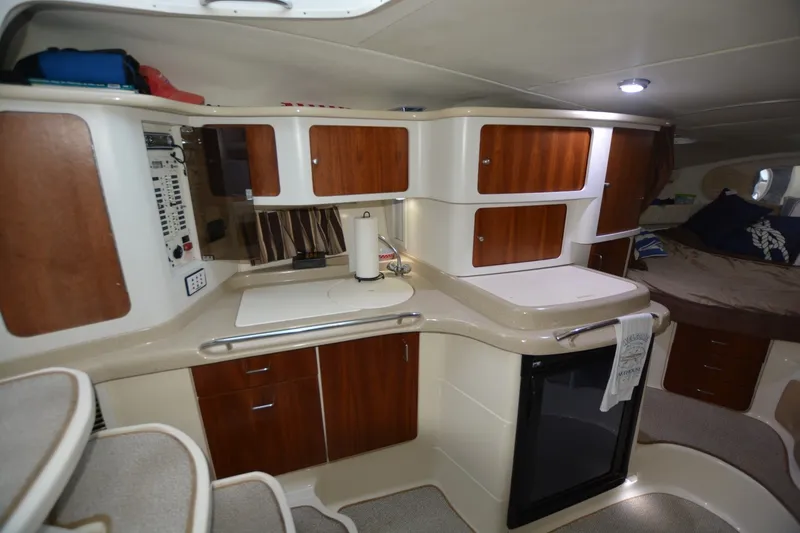 Slide: The Image of 2001 Chris-Craft 328 Express Cruiser interior with modern kitchen and cozy sleeping area. - 10