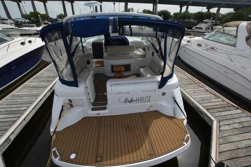 Slide: The Image of 2001 Chris-Craft 328 Express Cruiser docked, featuring spacious deck and blue canopy. - 4