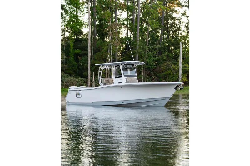 Slide: The Image of 2027 Sea Hunt Ultra 305SL boat on calm water, surrounded by lush trees. - 15