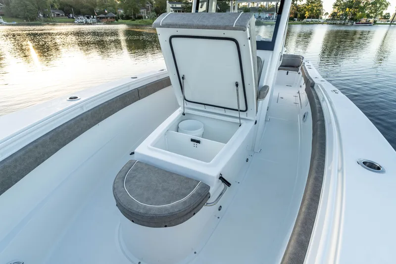 Slide: The Image of 2027 Sea Hunt Ultra 305SL boat interior with open storage compartment on calm water. - 21