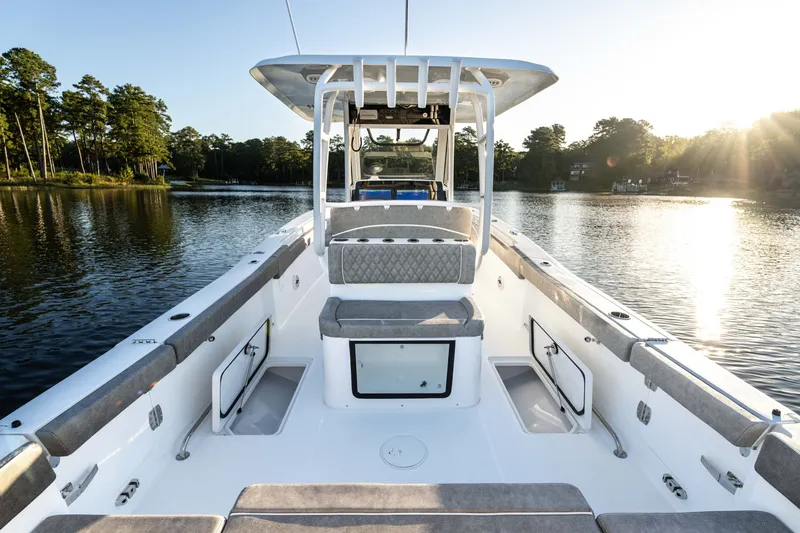 Slide: The Image of 2027 Sea Hunt Ultra 305SL boat interior on a serene lake at sunset. - 27