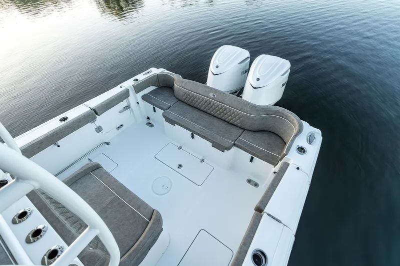 Slide: The Image of 2027 Sea Hunt Ultra 305SL boat with dual engines and spacious seating on calm water. - 17